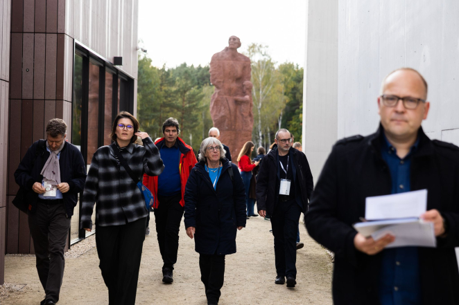 Grupa osób w Muzeum i Miejscu Pamięci w Sobiborze, w tle pomnik Matki z Dzieckiem.