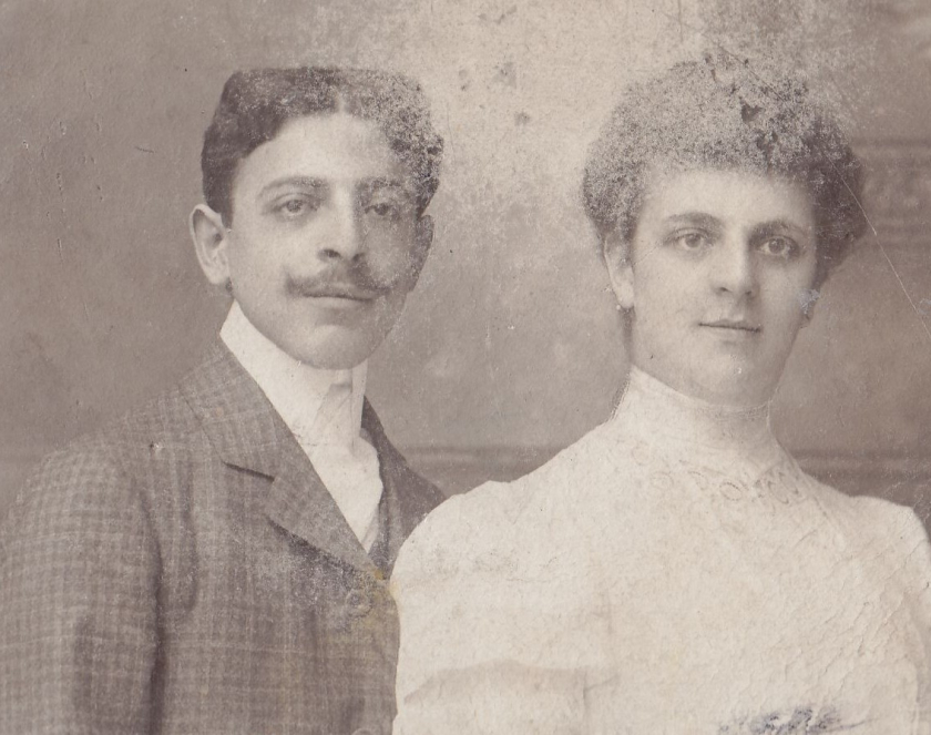 Zdjęcie portretowe mężczyzny i kobiety w średnim wieku, mężczyzna z podkręconym do góry wąsem, kobieta w białej sukni z upiętymi do góry włosami. 