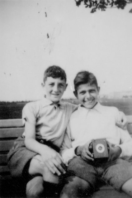 Czarno-białe zdjęcie, dwóch uśmiechniętych młodych chłopców. 