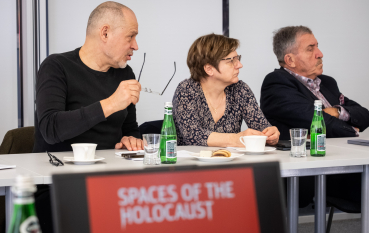 Dwóch mężczyzn i kobieta na pierwszym planie napis: Spaces of the Holocaust. 