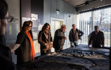 Grupa osób stojąca nad makietą. 